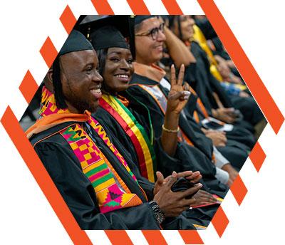 Female gradudate signing the V's Up!