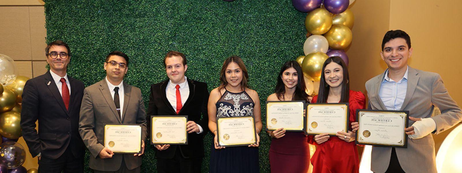 Students smile while holding award