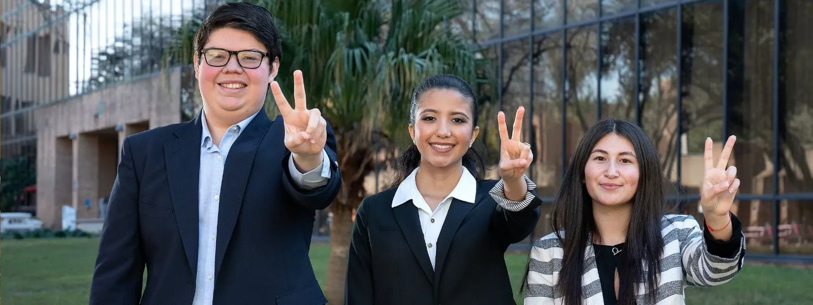 Finance students pose with the Vs up hand sign 