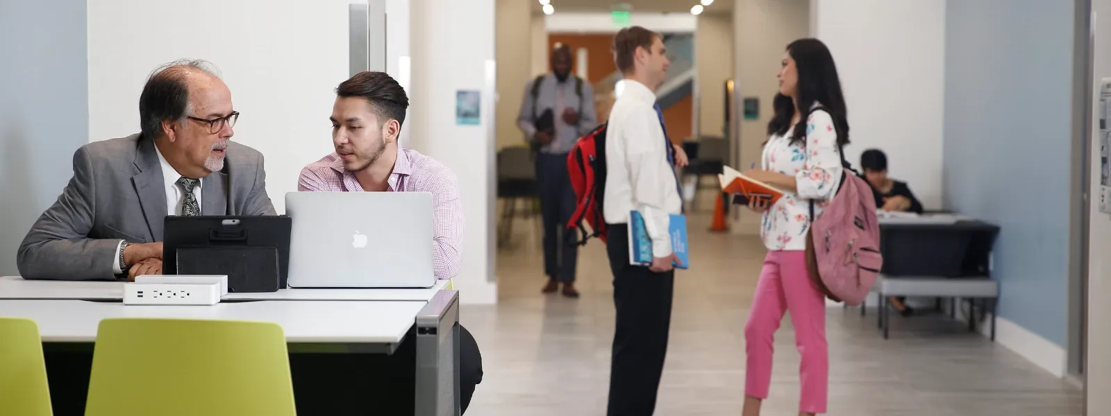 Students in discussion behind laptop