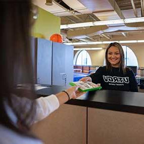 staff handing a video game disk to student